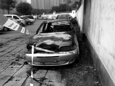 两轿车停在路边围墙下 凌晨起火被烧成空壳